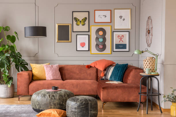 茶色のソファとトレンディな折衷的なリビングルームのインテリアでヴィンテージブラックプーフ - eclectic ストックフォトと画像