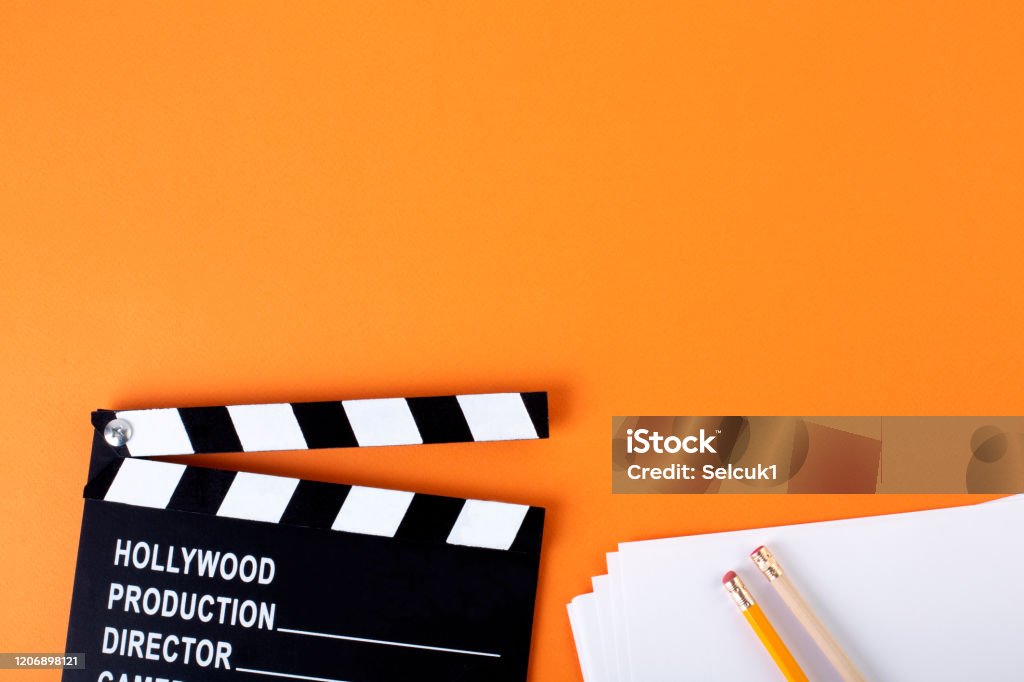 Movie clapper board on orange background with copy space. Home Video Camera Stock Photo