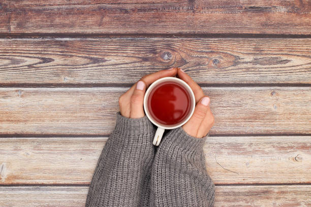 istock Hot healthy tea in woman's hands 1206898228