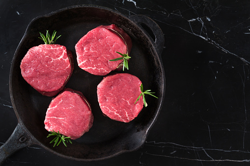 Beef steaks on iron pan.