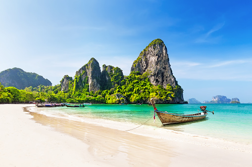 Thai traditional wooden longtail boat and beautiful sand Railay Beach in Krabi province. Ao Nang, Thailand.