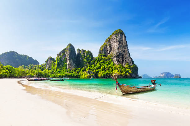 Thai traditional wooden longtail boat and beautiful sand beach. Thai traditional wooden longtail boat and beautiful sand Railay Beach in Krabi province. Ao Nang, Thailand. phi phi islands stock pictures, royalty-free photos & images