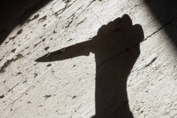 Shadow of the hand holding a knife stock photo