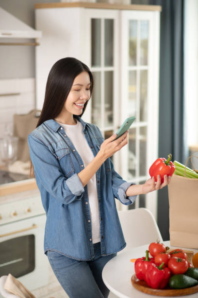 istock Young girl with a smartphone and red pepper. 1206902867