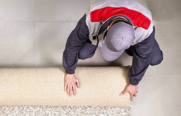 istock Male Worker Unrolling Carpet On Floor At Home, view from above 1206903875