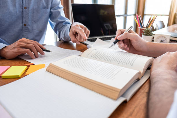 istock Tutor books with friends education, Group students studying and teaching helping and study course with books in library for learning tutoring homework a test or exam 1206904142