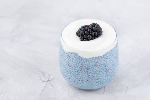 Blue chia seed pudding with blackberries in glass