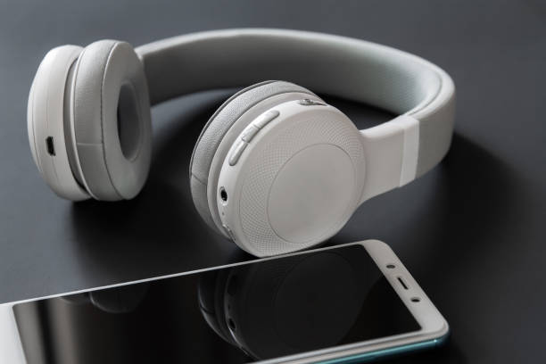 istock Wireless headphones and smartphone on the dark background. Closeup, selective focus 1206904470