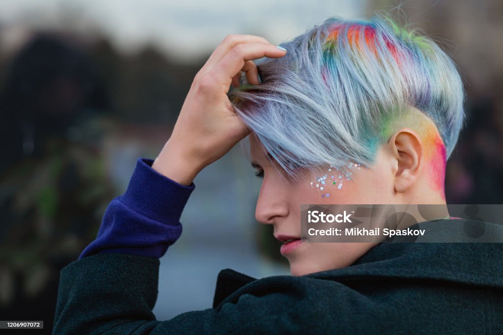 Portrait Of A Young Beautiful Woman In Green Coat With A Short Haircut And  Dyed Hair Grey Main Color And Yellow Green Blue And Red Hair Color Stock  Photo - Download Image