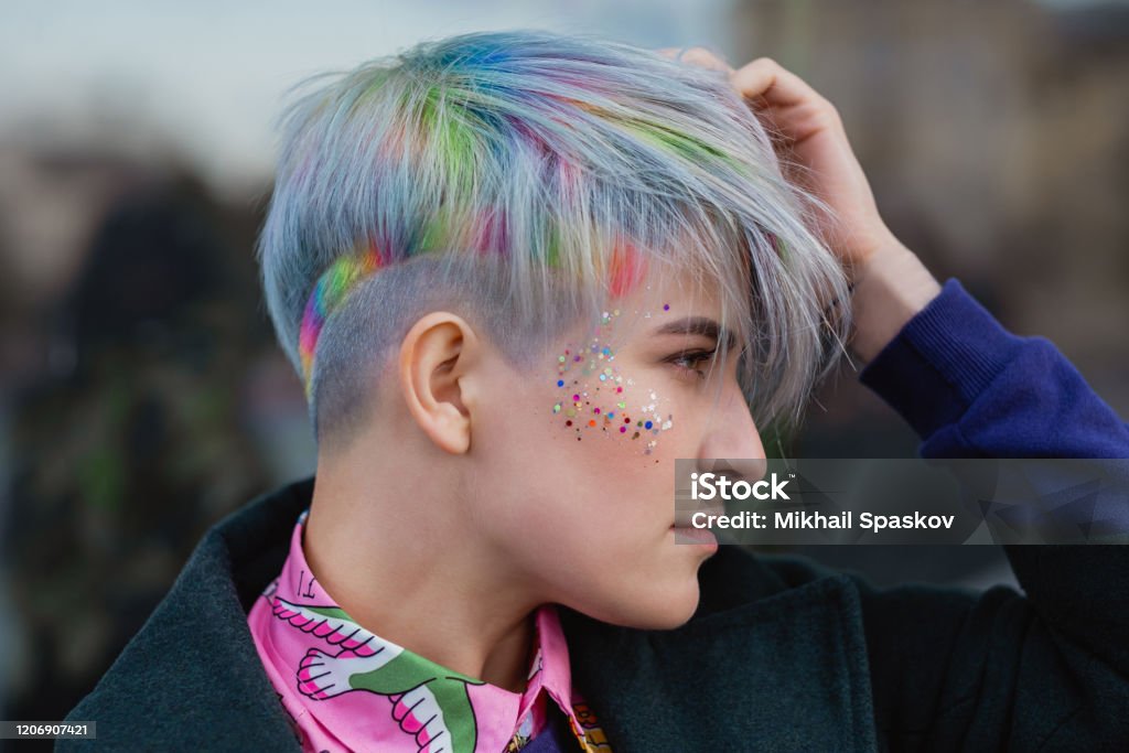 Portrait Of A Young Beautiful Woman In Green Coat With A Short Haircut And  Dyed Hair Grey Main Color And Yellow Green Blue And Red Hair Color Stock  Photo - Download Image