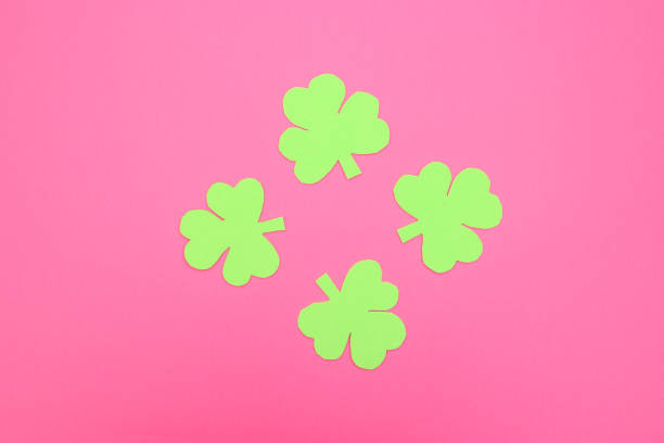 istock Green hand crafted clovers on colored background 1206918389