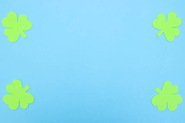 istock Green hand crafted clovers on colored background 1206918736