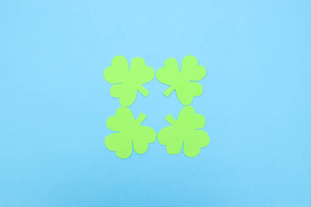 istock Green hand crafted clovers on colored background 1206919118