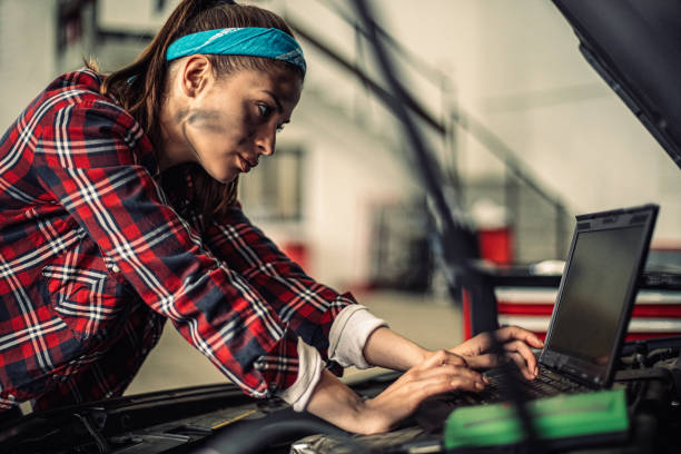 hermosa mujer mecánica con portátil. - adult manual worker automobile industry transportation fotografías e imágenes de stock