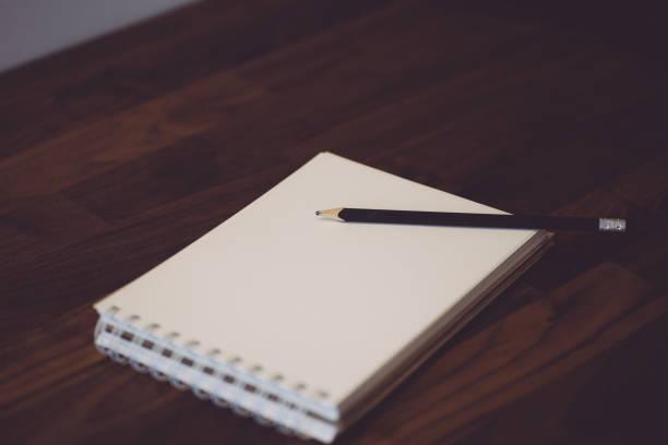 istock Notepad with pencil on a wooden table. White notebook (sketchbook) for sketches or notes 1206920891