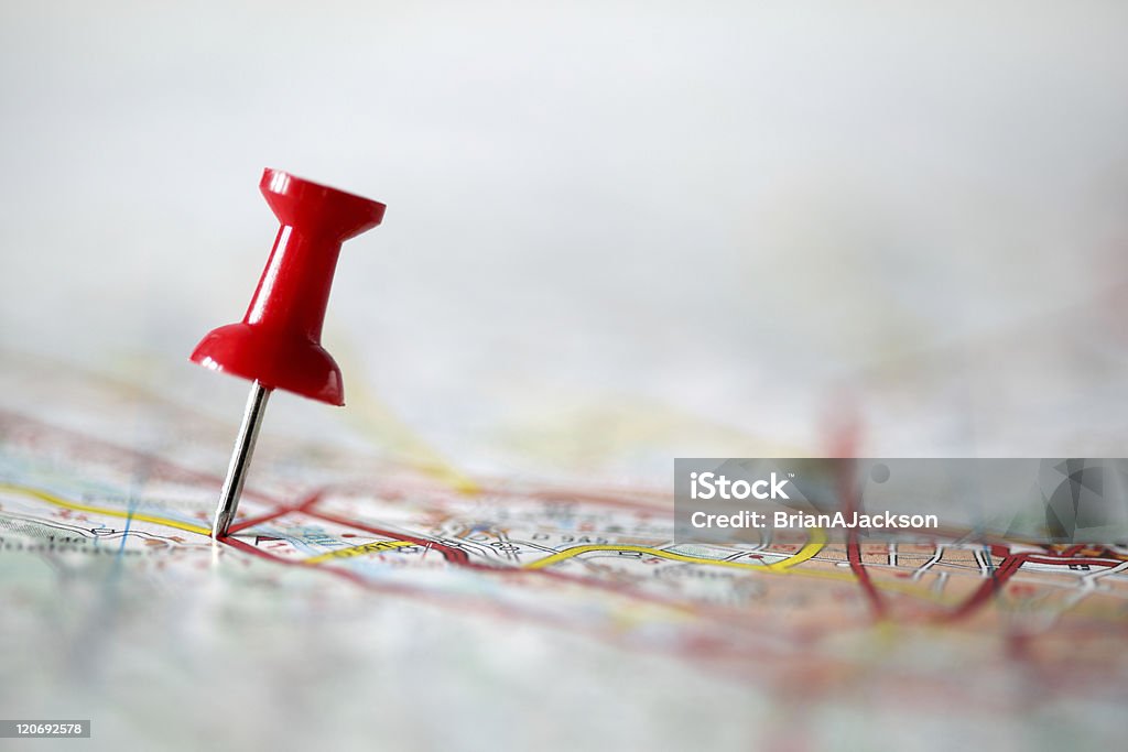 Pushpin on map Red pushpin showing the location of a destination point on a map Map Stock Photo