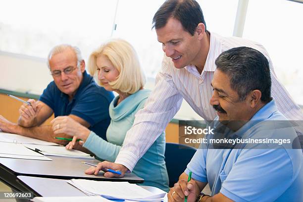 Teacher Assisting Mature Student In Class Stock Photo - Download Image Now - Nontraditional student, Classroom, Senior Adult