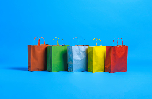 Studio shot of shopping bags on blue background.