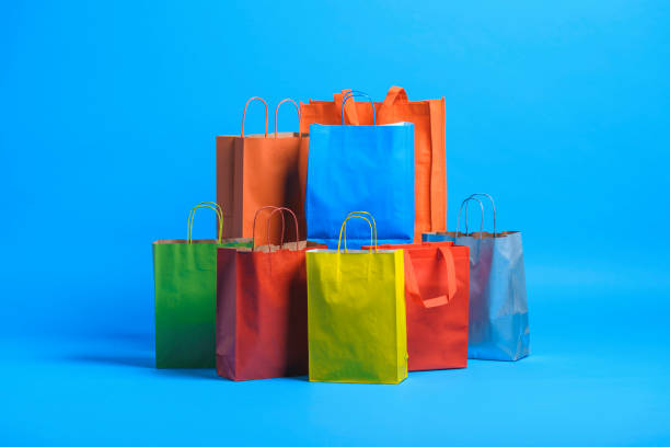 Studio shot of shopping bags on blue background.