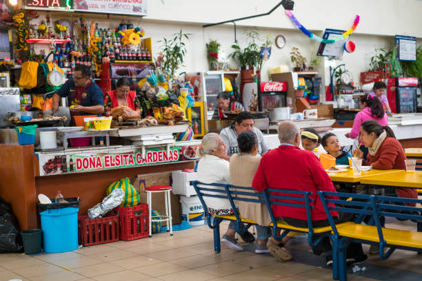 pessoas têm churrasco assado pig oferecido no mercado de agricultores em cuenca, equador - roasted spit roasted roast pork barbecue grill - fotografias e filmes do acervo