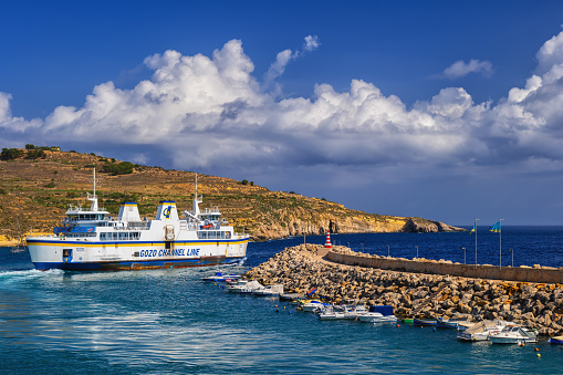 Gozo, Malta - October 15, 2019: Gozo Channel Line ferry boat leaving the harbor on Gozo island in direction to Malta island, main way of transport between two Maltese islands in the Mediterranean Sea
