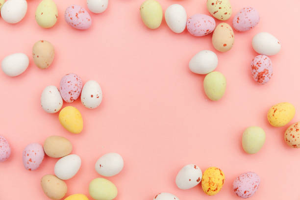 istock Happy Easter concept. Preparation for holiday. Easter candy chocolate eggs and jellybean sweets isolated on trendy pastel pink background. Simple minimalism flat lay top view copy space 1206930130