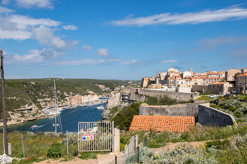 Town on rocky cliffs with clear sky and calm blue sea beneath,  summer / spring
