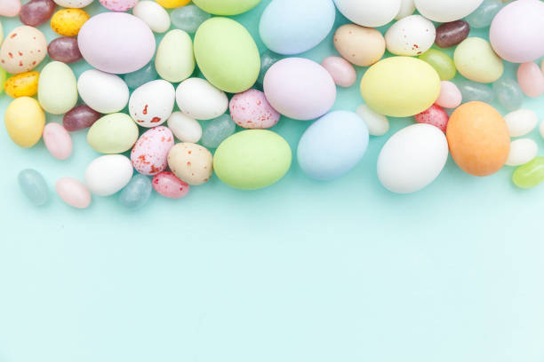 istock Happy Easter concept. Preparation for holiday. Easter candy chocolate eggs and jellybean sweets isolated on trendy pastel blue background. Simple minimalism flat lay top view copy space 1206933595
