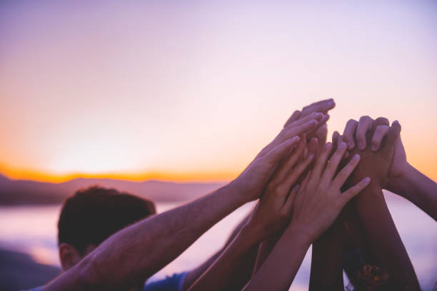 istock Group of people holding hands and doing a high five in celebration and friendship. 1206934501