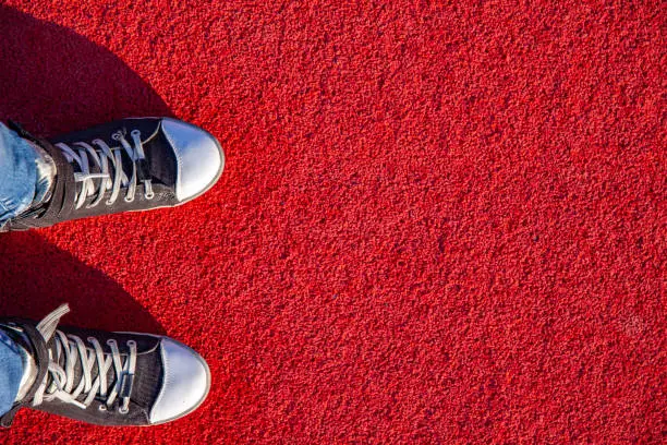 High Angle View on Feet in Sneakers Standing on Synthetic Running Track.