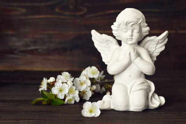 istock Guardian angel and spring flowers on dark background 1206940536