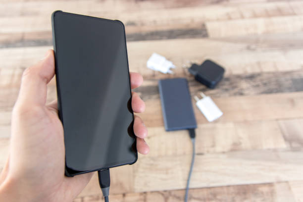 istock Hand holding phone connected to power bank 1206942284