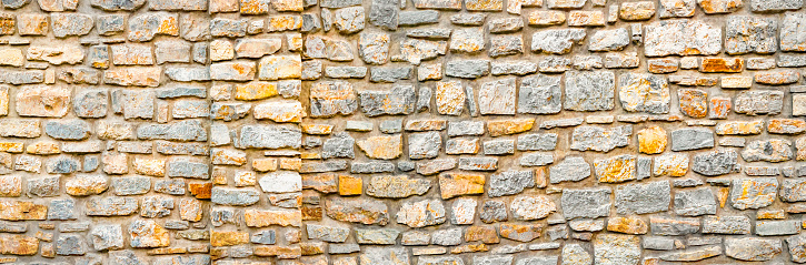 Stone wall banner, background. Wall pattern texture background. Surface with asymmetrical stones. Old wall of ancient architecture. Rome, greek culture, architecture. Fragment of historic building