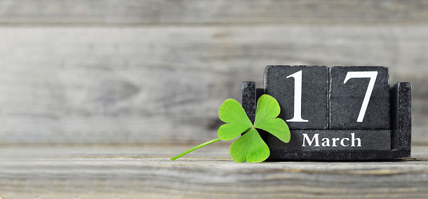 St Patricks Day background or banner with copy space. Vintage calendar and shamrock on wooden background