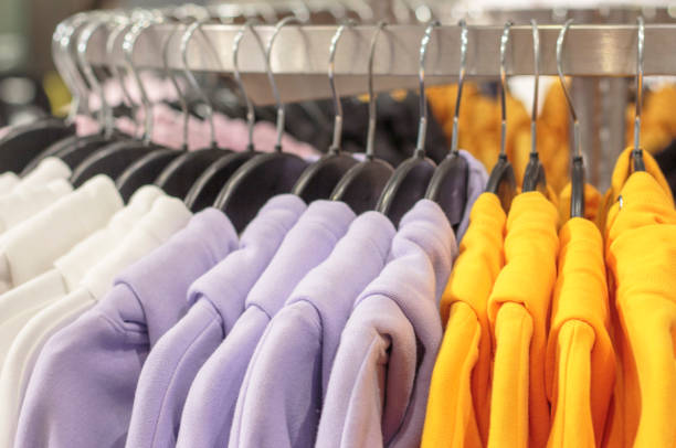 istock Multicolored sweatshirts hang on a hanger in store close-up. 1206951266