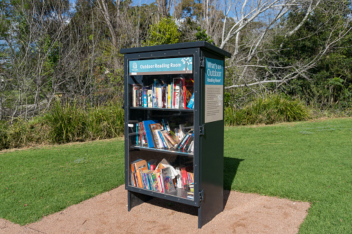 Wollongong, Australia - September 20, 2015: Outdoor library bookcase with books in Wollongong Botanic Garden on sunny day