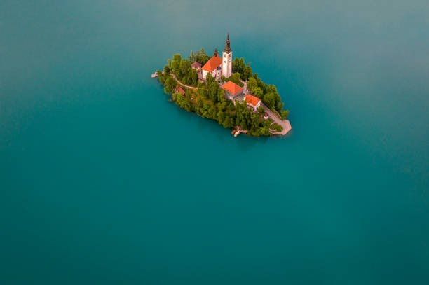vista drone dell'isola solitaria con chiesa nel mezzo del lago d'acqua turchese - santa maria church foto e immagini stock