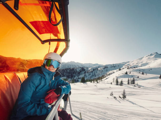 istock Smiling woman sitting on a ski lift 1206955129
