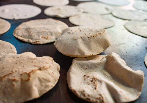 Handmade corn tortillas puffing up while cooking on a griddle stock photo