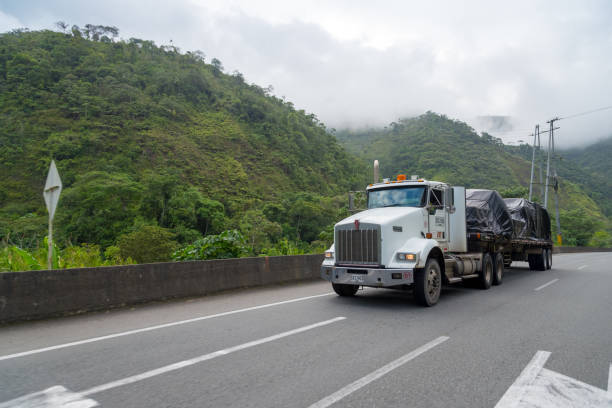 Truck on road between mountains with fog. Valle del Cauca  . Colombia. October 30, 2019.