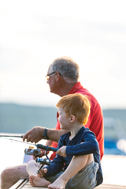 avô e neto pescando ao pôr do sol no verão - fishing lake grandfather grandson - fotografias e filmes do acervo