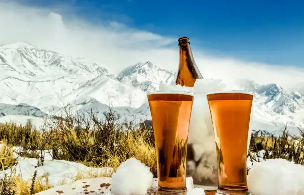 Photo of Tasty and fresh craft red beer at the foot of the snowy mountain.