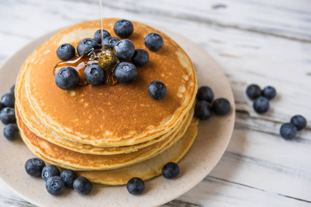 istock Close up of a stack of fluffy pancakes with maple syrup poured over them 1206969908