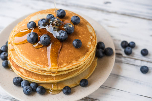 istock Close up of a stack of fluffy pancakes with maple syrup poured over them 1206969913