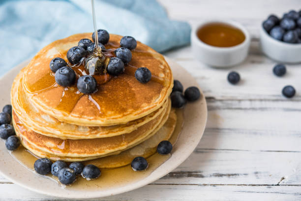 istock Close up of a stack of fluffy pancakes with maple syrup poured over them 1206969914