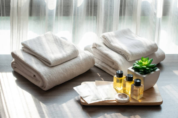 reeks van hotel voorzieningen ( zoals handdoeken, shampoo, zeep etc) op het bed. - hotel shampoo stockfoto's en -beelden