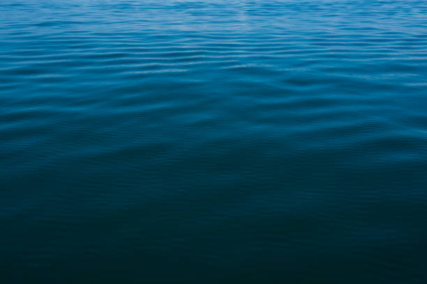 Serene turquoise water surface with gentle ripples reflecting the soft light of the sky, creating a tranquil and peaceful atmosphere
