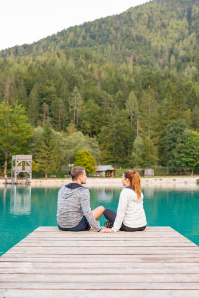istock Romantic Couple Sitting on a Jetty at a Mountain Lake 1206977445