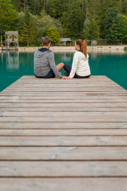 istock Romantic Couple Sitting on a Jetty at a Mountain Lake 1206977452