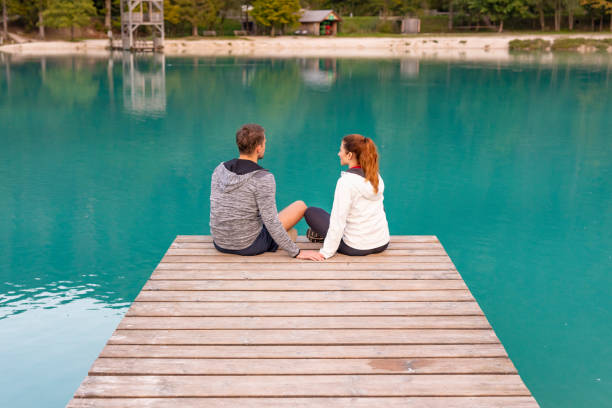 istock Romantic Couple Sitting on a Jetty at a Mountain Lake 1206977472